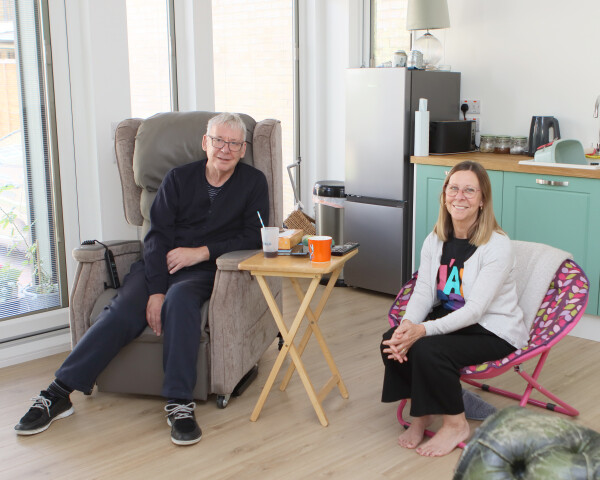 Richard and Moira in the lounge of their accessible garden annexe, featuring guidance from Farleigh Hospice. Richard and Moira sitting together in the lounge of their newly built garden annexe, with adaptations recommended by Farleigh Hospice for accessibility.